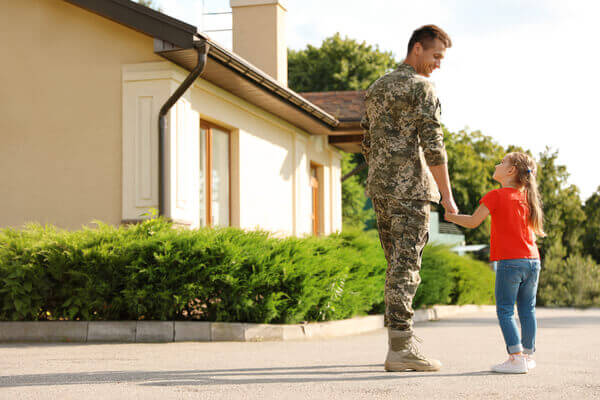 Military service member walking his daughter on base