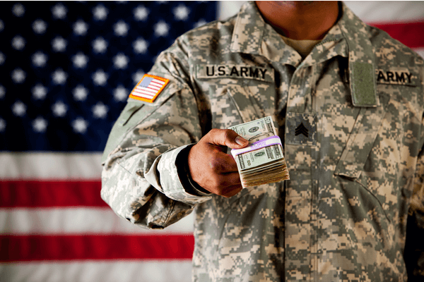 military vet holding out stack of money as if loaning it to someone