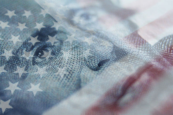 American flag behind a US twenty dollar bill