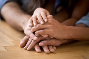 Family that adopted a child with their hands on the table