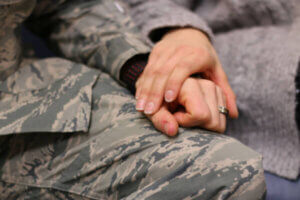Military spouse holding hands with her husband