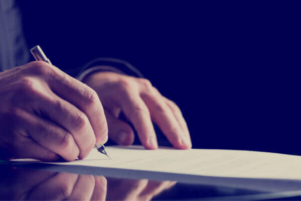 Military member filling out his will on a desk