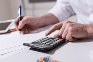 Retired military veteran checking his pay on a calculator