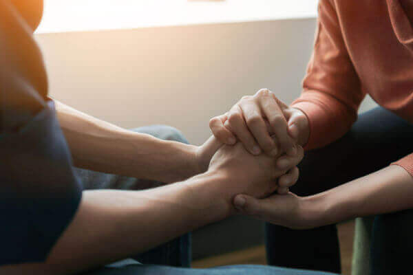 Veteran holding hands with a healthcare worker