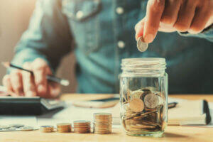 Man counting up his savings in a coin jar