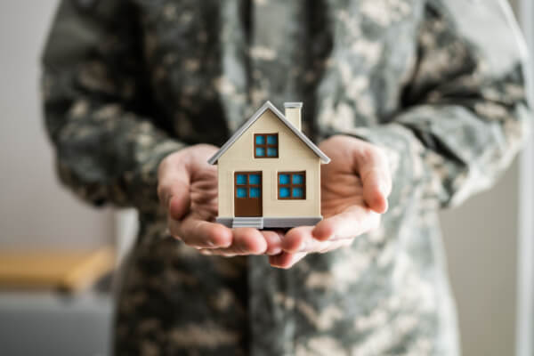 Military member holding a small model house