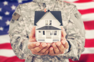 Military member holding a model house