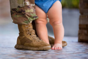 Military servicemember standing with child