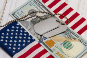 Dog tags stacked on money and the American Flag