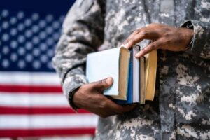 Young student soldier In uniform with books.