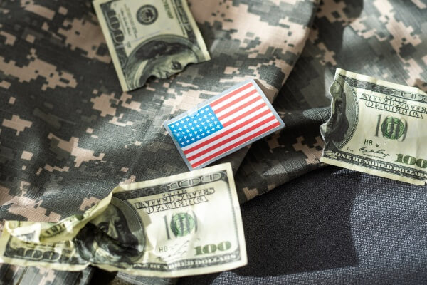 USA flag and money. Cash for VA loan from U.S. Department of Veterans Affairs.
