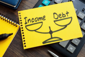 Debt to income ratio DTI concept. Page from a notebook with drawn weights lies on a calculator.