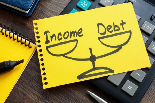 Debt to income ratio DTI concept. Page from a notebook with drawn weights lies on a calculator.